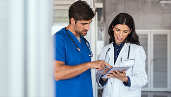 Interne et médecin regarde une tablette