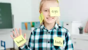 Enfant avec des post-it sur lesquels sont écris des mots en anglais