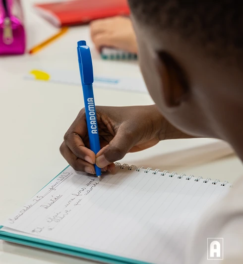 Un élève de primaire suit un cours Acadomia et écrit ses leçons - photo tous droits réservés