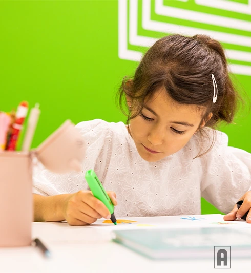 Une élève de primaire suit un cours Acadomia et écrit ses leçons - photo tous droits réservés
