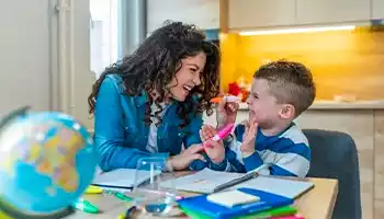 Enfant et sa mère s'amusent en faisant les devoirs