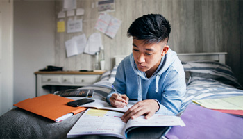 Lycéen fais ses devoirs dans sa chambre