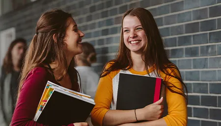 Deux lycéennes discutent dans un couloir