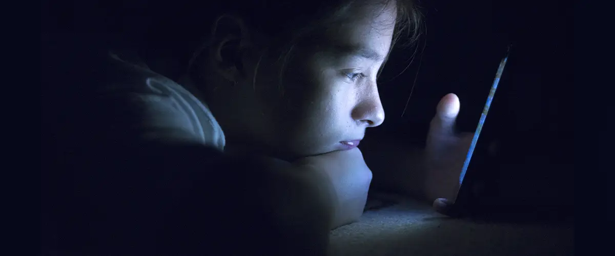 Enfant la nuit sur son téléphone