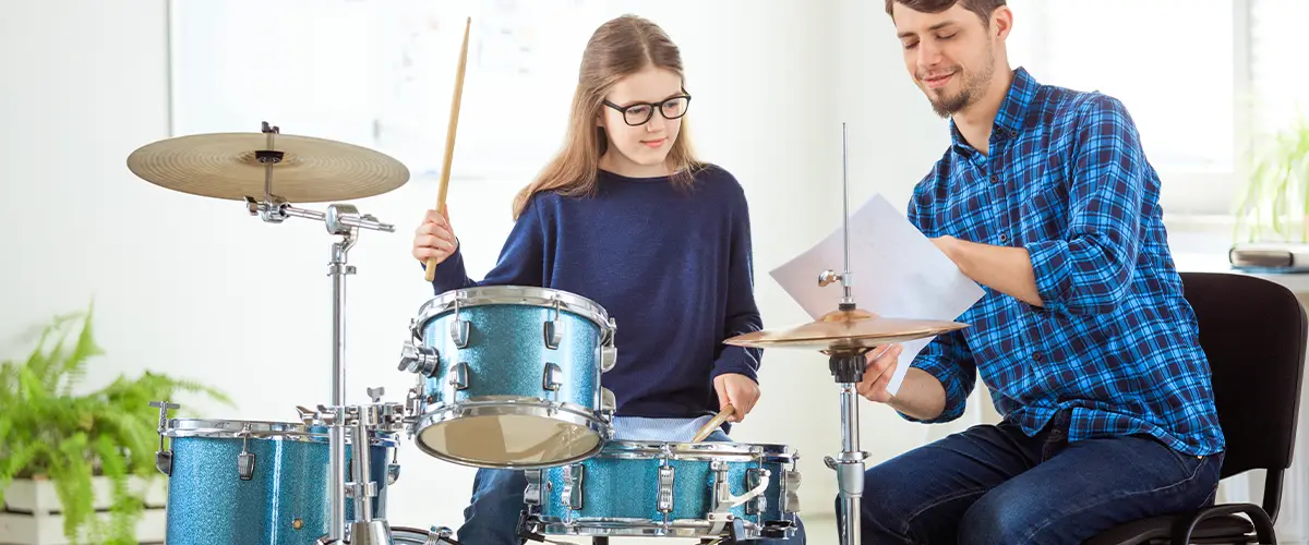 Adolescente en cours particulier de batterie avec un prof Acadomia