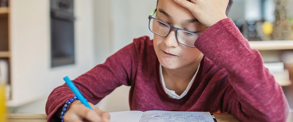 Elève au collège fatigué devant ses devoirs