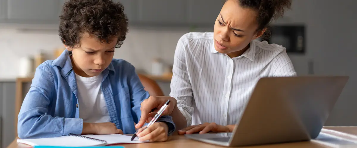 Mère aide son enfant pour les devoirs à la maison - Acadomia