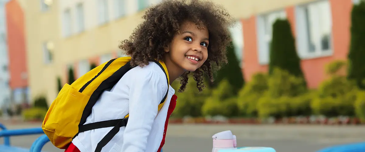 Jeune élève souriante avec son sac à dos de rentrée - Acadomia