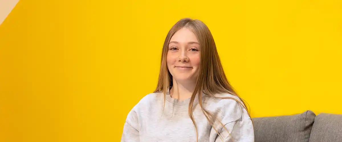 Une lycéenne souriante pose dans un espace d'accueil Acadomia - photo tous droits réservés