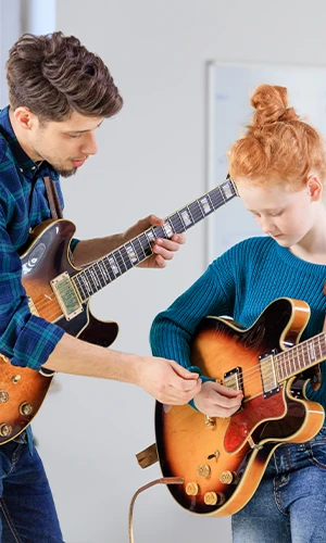 Un professeur de musique Acadomia en cours de guitare avec une élève