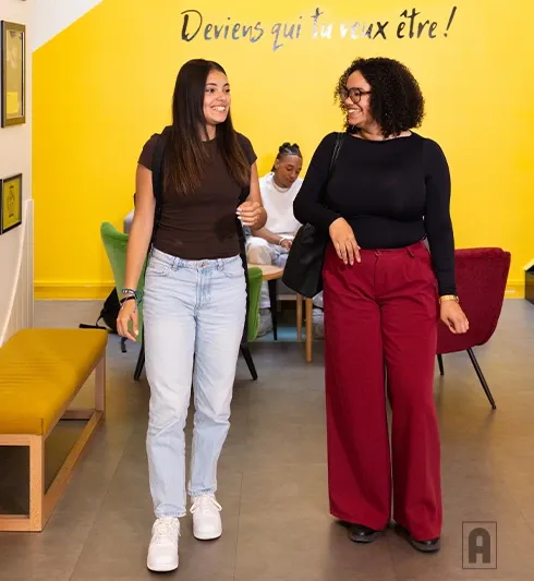 Deux lycéennes heureuses qui marchent dans une salle Acadomia avec slogan 