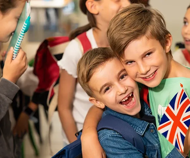 Elèves de primaire heureux avec un drapeau anglais en centre Acadomia - photo tous droits réservés