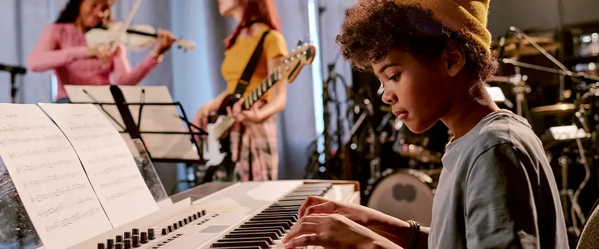 Jeune adolescent pratiquant le clavier en cours de musique Acadomia