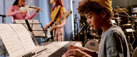 Jeune adolescent pratiquant le clavier en cours de musique Acadomia