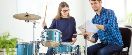 Adolescente en cours particulier de batterie avec un prof Acadomia