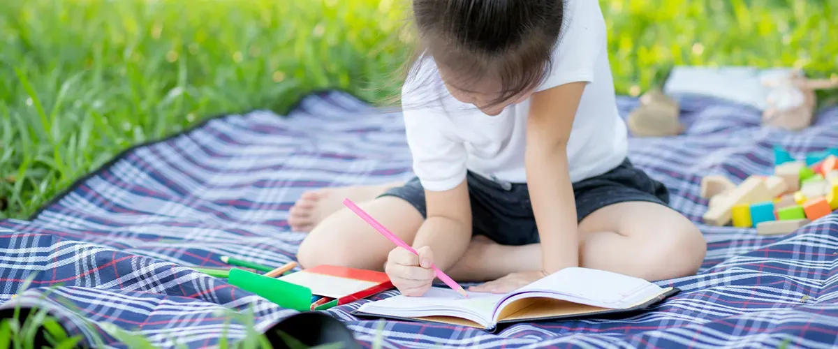 Une élève de primaire qui fait ses devoirs de vacances - Acadomia