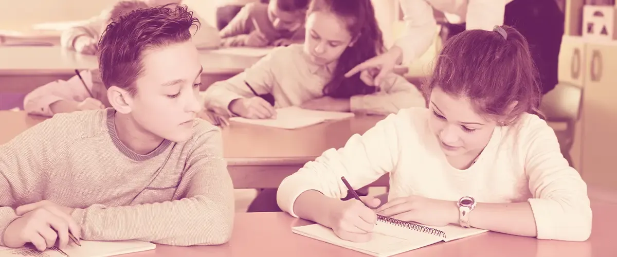Classe avec des élèves de 6e dans les années 90 qui écrivent une dictée sur leur cahier - Acadomia