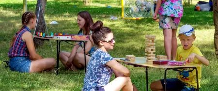 Enfants et parents jouant à des jeux dans un espace de plein air.