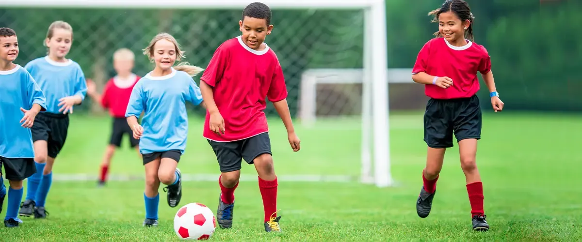 Enfants jouant au football - Acadomia