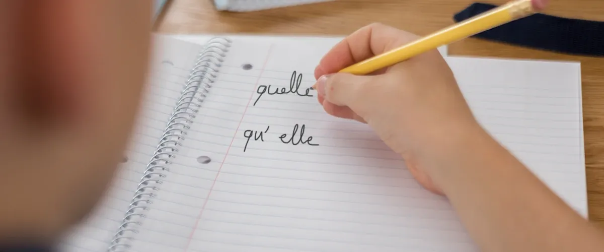 Cahier d'école avec texte "Quelle et qu'elle" - exercice orthographe avec Acadomia