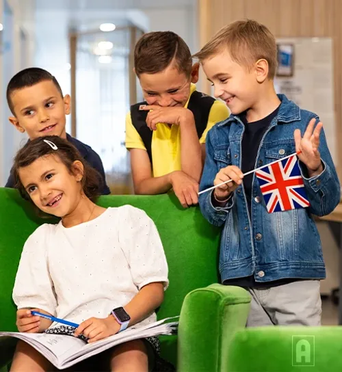 Groupe d'élèves de primaire heureux qui tiennent un drapeau anglais avec Acadomia - photo tous droits réservés