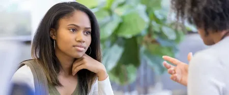 Une lycéenne attentive écoute les explications de son professeur lors d'un cours particulier Acadomia