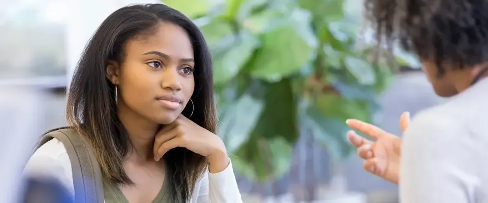 Une lycéenne attentive écoute les explications de son professeur lors d'un cours particulier Acadomia