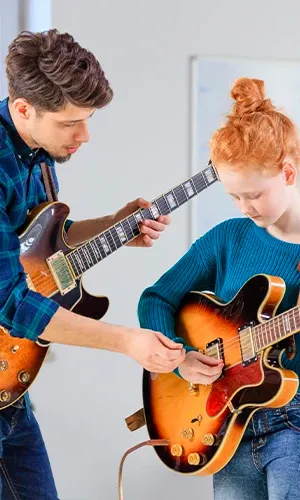 Un professeur de musique Acadomia en cours de guitare avec une élève