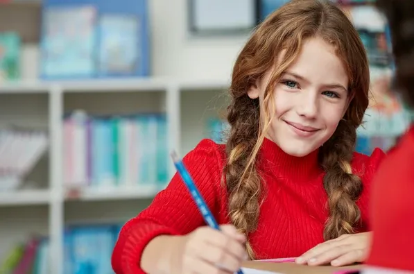 Une élève de primaire prend des notes lors d'un cours collectif Acadomia